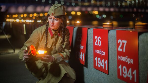 Участница патриотической акции Линия памяти зажигает свечу на Крымской набережной вдоль Москвы-реки в память о погибших в Великой Отечественной войне Участница патриотической акции Линия памяти зажигает свечу на Крымской набережной вдоль Москвы-реки в память о погибших в Великой Отечественной войне